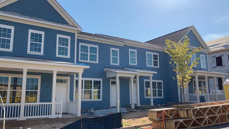 Blue house exterior with white trim, porch columns and a wooden deck