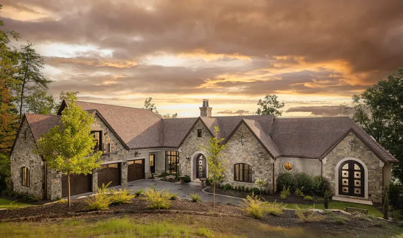 Acqua Bella, a stone residence with arched windows and an arched garage entrance