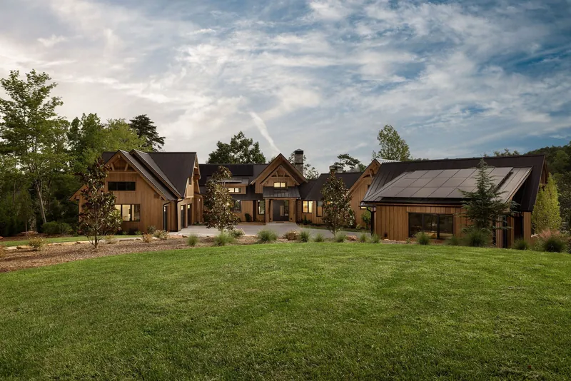 Baystone Landing, a wood-clad residence with gabled roofs beside a green lawn