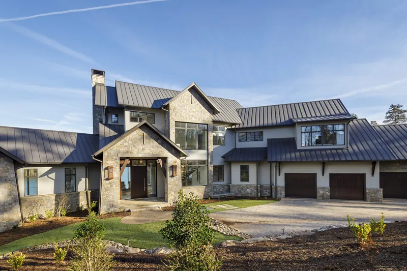 Modern Lake Haven, a contemporary home with stone walls, tall windows and metal roofs